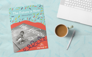 Way to Grow's 2024 Annual Report on a blue tablecloth with a laptop, coffee mug, and pen.