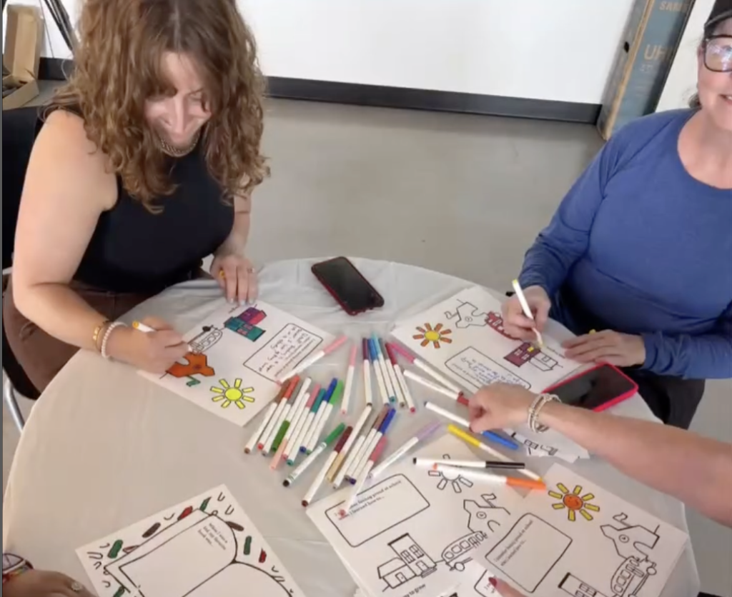 Volunteers color inspiration coloring sheets and write messages with markers.