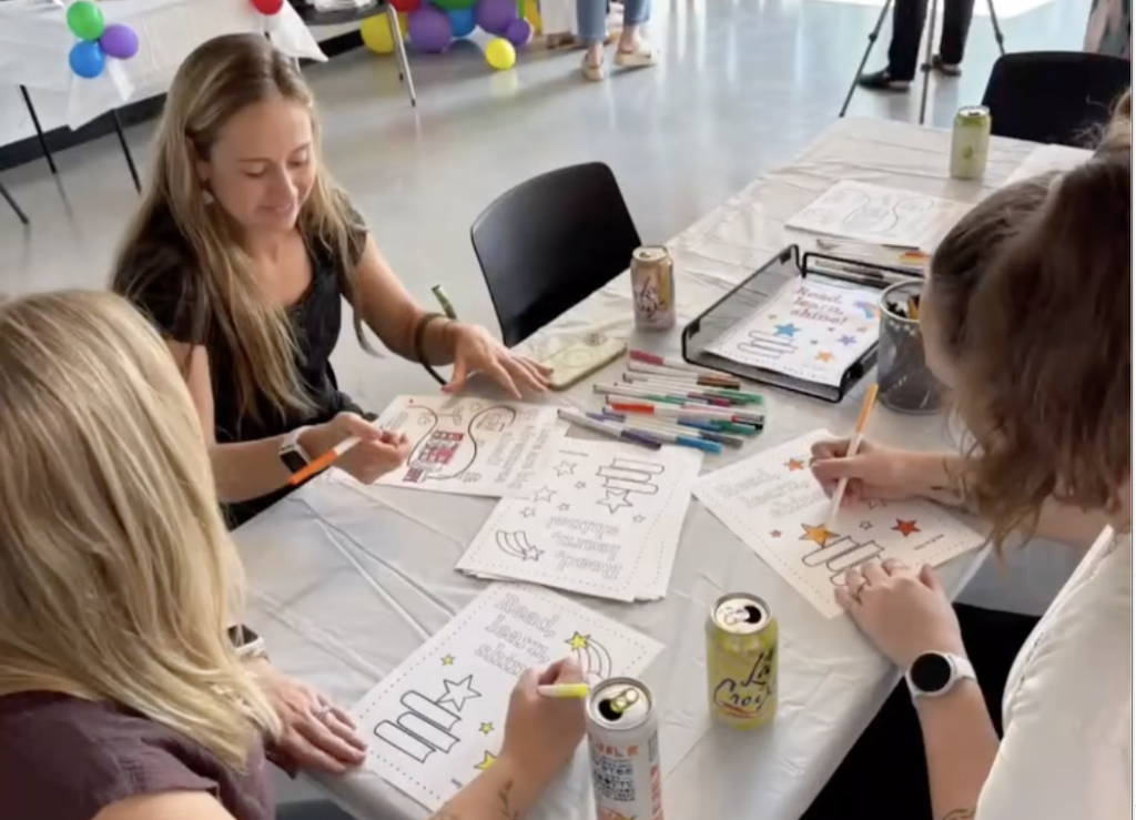 Volunteers color inspiration coloring sheets and write messages with markers.