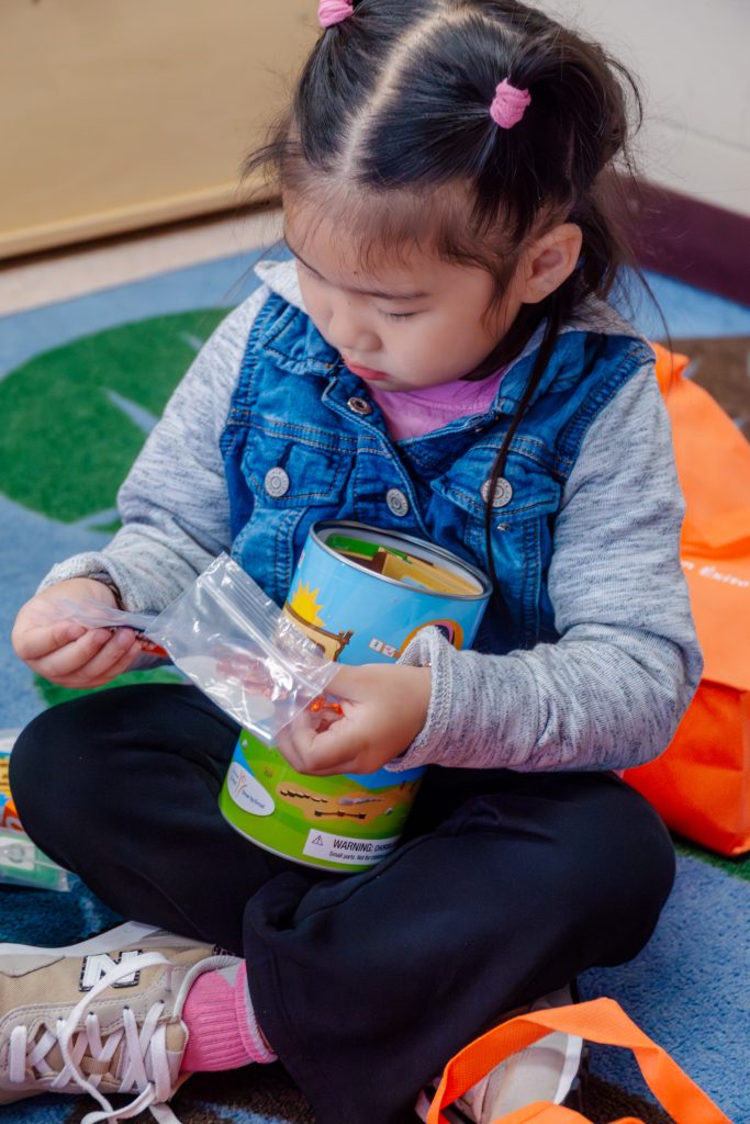 Preschooler opens math manipulatives.