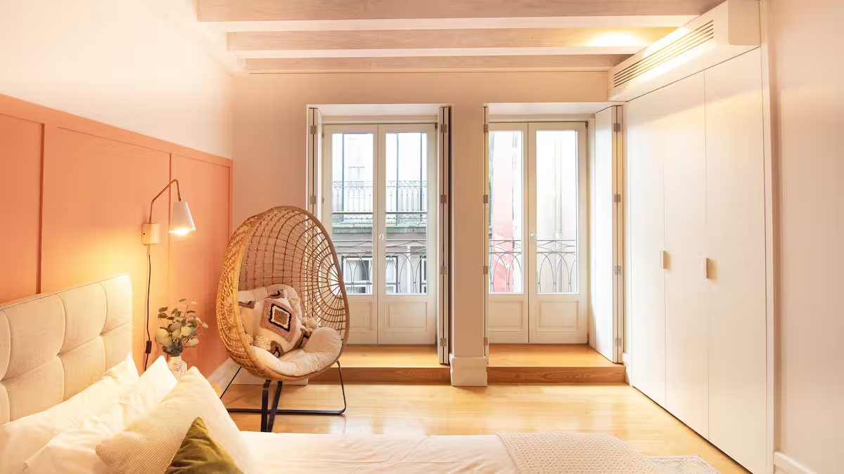 A bright bedroom in the Porto apartment with tall French doors