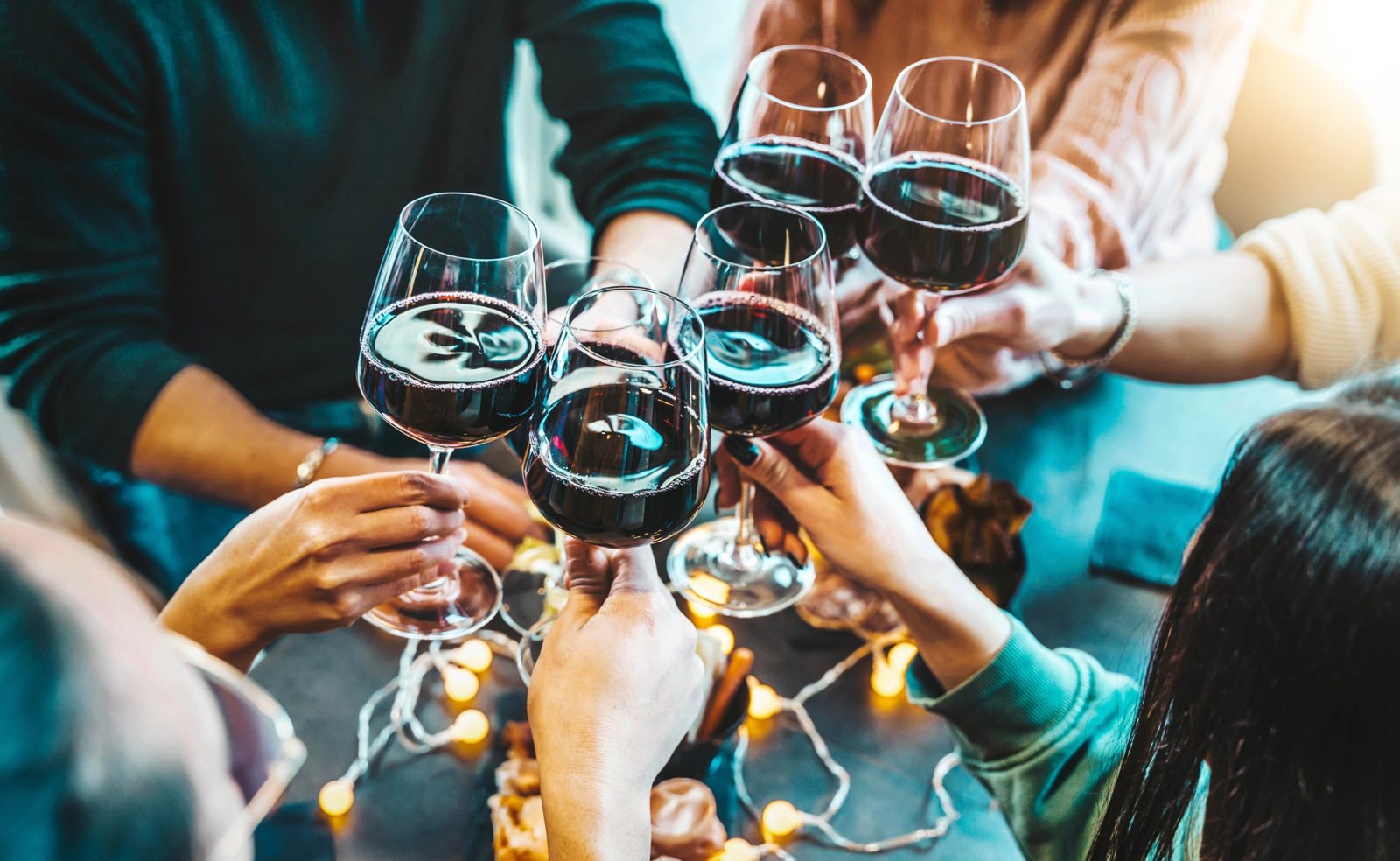 Friends raising glasses of red wine around a table
